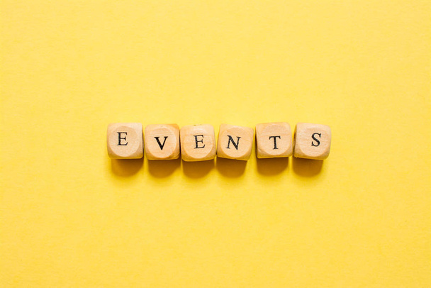 the word Events, text made with dice on yellow background - Photo, image