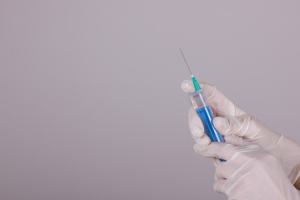 medical gloves and syringe with needle - Foto, imagen