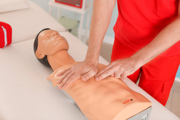 Istruttore che dimostra CPR sul manichino al corso di primo soccorso
 - Foto, immagini