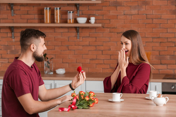 Young man proposing to his beloved at home - Photo, Image