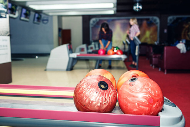 різнокольорові кульки для боулінгу лежать на полиці в клубі боулінгу
. - Фото, зображення