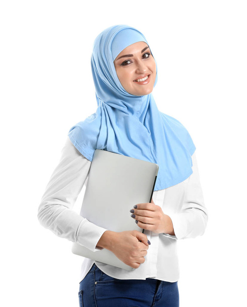 Beyaz arka planda dizüstü bilgisayarı olan genç bir Arap kadın. - Fotoğraf, Görsel