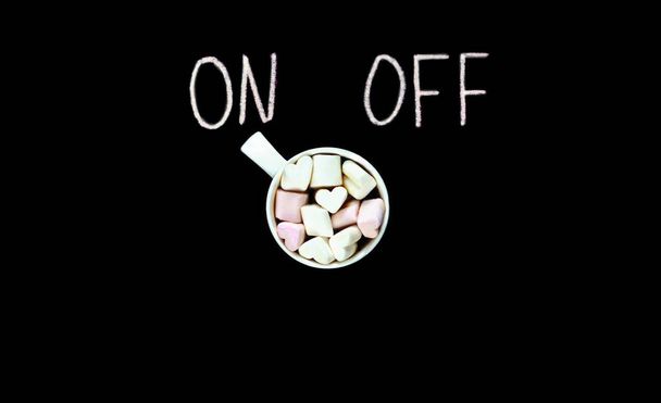 Cup Of Coffee With On Off Switch. marshmellows decorated coffee. morning motivation. black background. - Photo, Image
