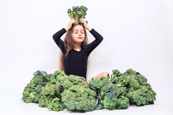 little girl cheerfully holding head of broccoli and smiling. healthy organic food concept. - Φωτογραφία, εικόνα