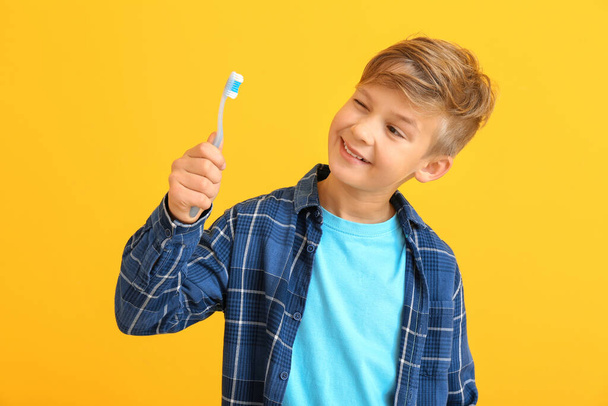 Cute little boy with toothbrush on color background - Foto, afbeelding