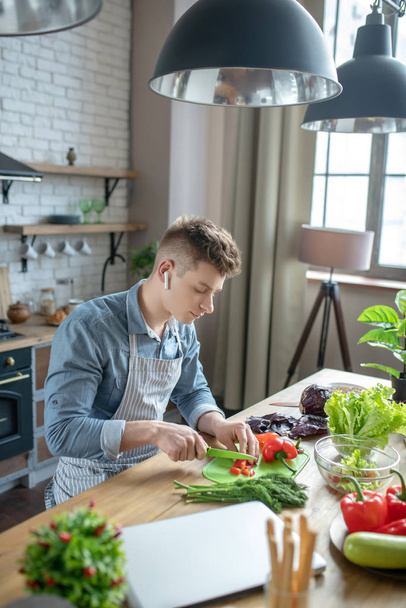 Attractive young man cooking a vegetable dish. - Fotó, kép