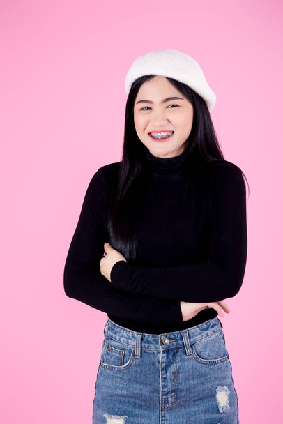 Crossed arms Asian woman wearing black sweater on pink background, lifestyle concept. - Fotoğraf, Görsel