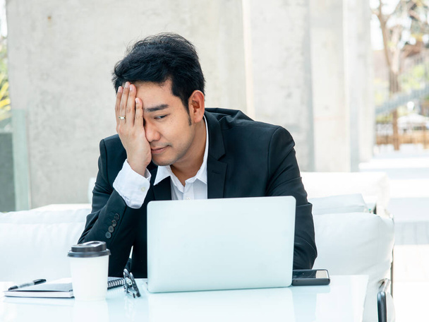 Stressed Asian businessman while working with laptop. - Zdjęcie, obraz