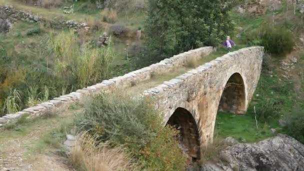 Ένα παιδί διασχίζει μια αρχαία Βενετική γέφυρα. Κυματιστά χέρια, παίζοντας με πολύχρωμες κορδέλες. - Πλάνα, βίντεο