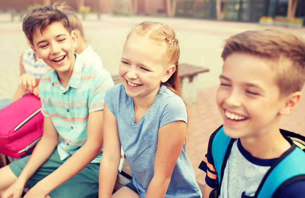 группа счастливых учеников начальной школы, говорящих
 - Фото, изображение