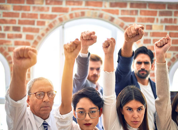 Група бізнесменів, що стоять з кулаками в офісі
 - Фото, зображення