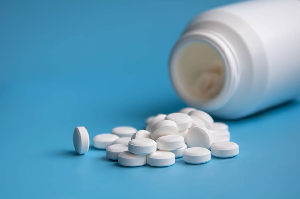 pastillas o comprimidos blancos para virus sobre fondo azul
 - Foto, Imagen