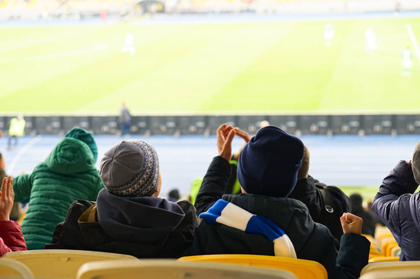 dzieci oglądające podczas gry z miejsc dla widzów na stadionie - Zdjęcie, obraz