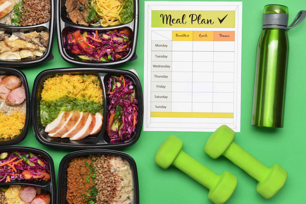 Containers with healthy food, bottle of water, dumbbells and meal plan on color background - Photo, Image