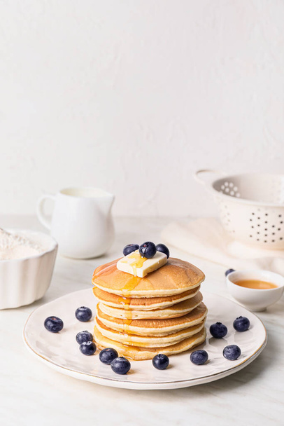 Tasty pancakes with honey, butter and berries on table - Fotografie, Obrázek