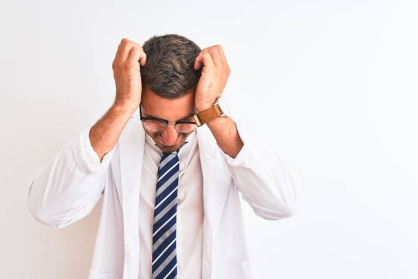 Mladý pohledný terapeut muž přes izolované pozadí trpí bolestí hlavy zoufalý a vystresovaný, protože bolest a migréna. Ruce za hlavu. - Fotografie, Obrázek