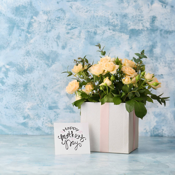 Schachtel mit Blumenstrauß zum Muttertag auf dem Tisch - Foto, Bild