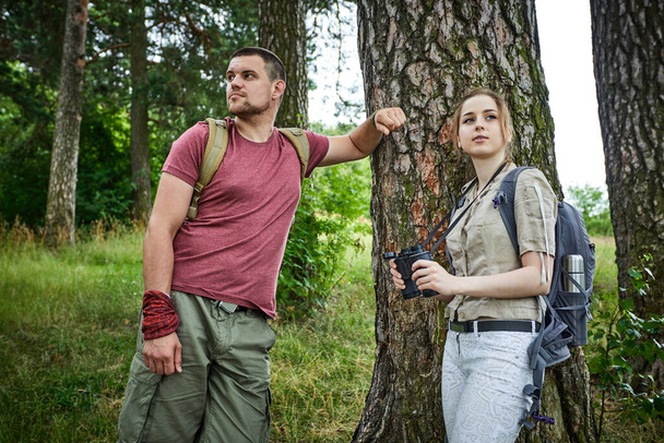 δύο ταξιδιώτες που βρίσκονται σε λιβάδι κοντά στο δάσος την ηλιόλουστη μέρα  - Φωτογραφία, εικόνα