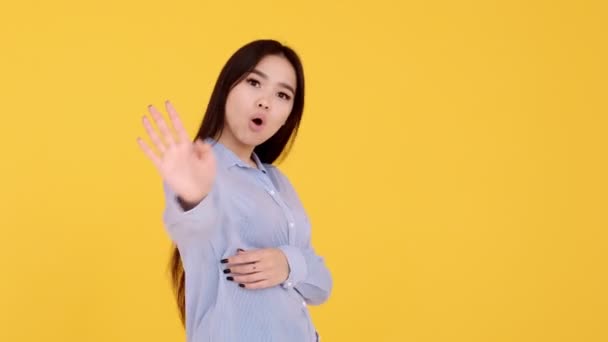 girl on a yellow background screams no. woman Asian girl denies dissatisfaction - Filmati, video