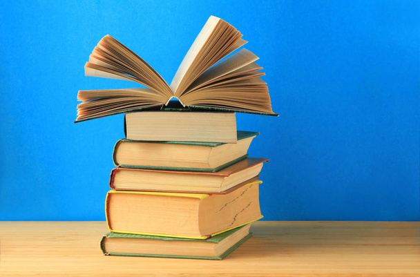 A stack of a book on the table on a blue background.Copy space. - Foto, Imagen