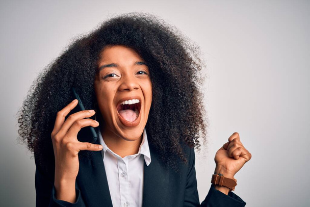 Afro saçlı genç Afrikalı Amerikalı iş kadını arıyor. Akıllı telefon kullanıyor. Gururla bağırıyor, zaferi ve başarıyı kutluyor. - Fotoğraf, Görsel