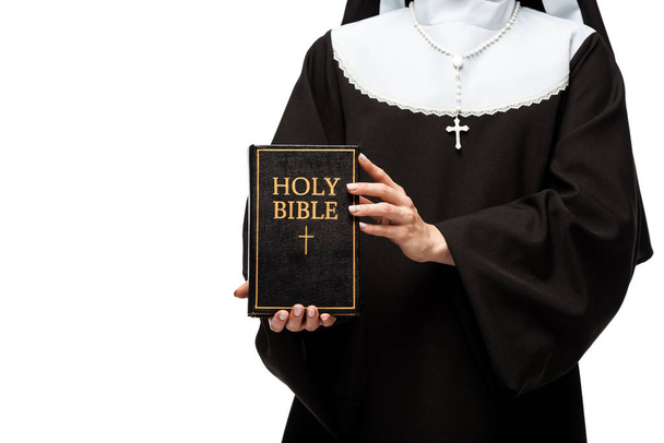 cropped view of nun holding holy bible isolated on white - Фото, изображение