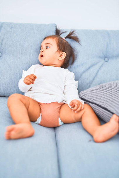Младенец радуется красочным игрушкам на диване
 - Фото, изображение