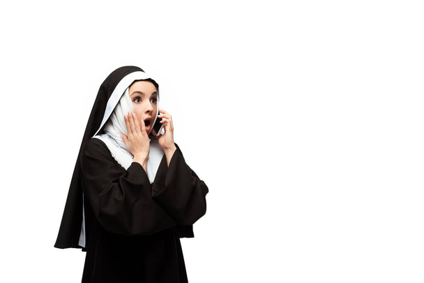 surprised nun talking on smartphone isolated on white - Foto, imagen