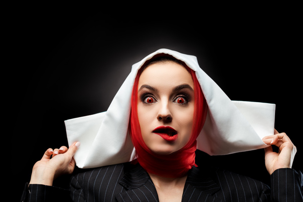 atraente sexy demonic freira com olhos vermelhos mordendo lábio isolado no preto
 - Foto, Imagem