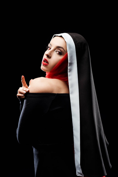 houkutteleva seksikäs nunna poseeraa musta mekko ja punainen huivi, eristetty musta
 - Valokuva, kuva