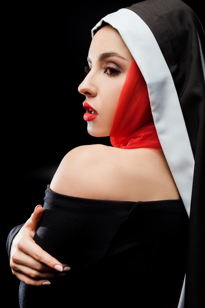 hermosa monja sexy posando en vestido negro y bufanda roja, aislado en negro
 - Foto, imagen