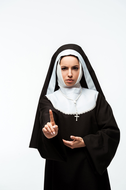 серьезная монахиня в черной одежде с предупреждающим знаком, изолированная на белом
 - Фото, изображение