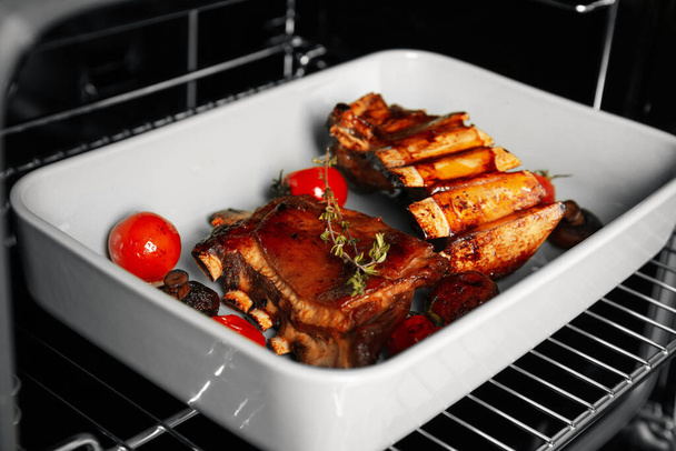 Delicious roasted ribs in oven, closeup. Yummy meat - Foto, Imagem