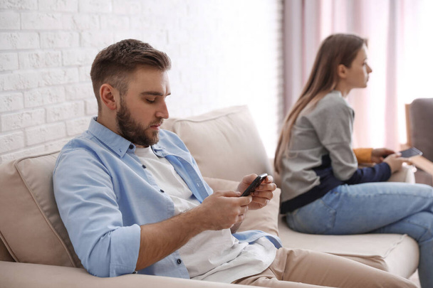 Couple addicted to smartphones ignoring each other at home. Relationship problems - Фото, зображення