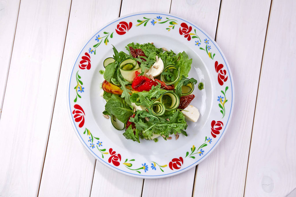 kesäkurpitsa rullina tuoretta salaattia valkoisella lautasella, lähikuva
 - Valokuva, kuva