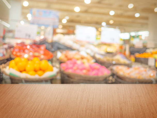 Prázdný dřevěný stůl na rozmazání supermarketu, oddělení ovoce, pro zobrazení montážních produktů - Fotografie, Obrázek