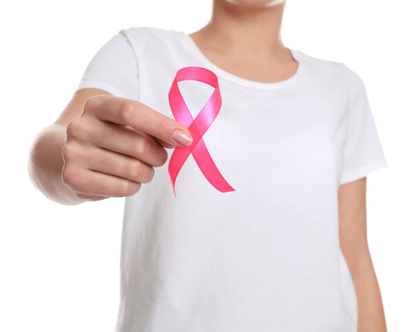 Mujer sosteniendo cinta rosa sobre fondo blanco, primer plano. Concientización sobre el cáncer de mama
 - Foto, Imagen