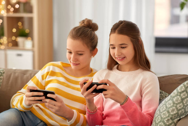 happy teenage girls with smartphones at home - Фото, зображення