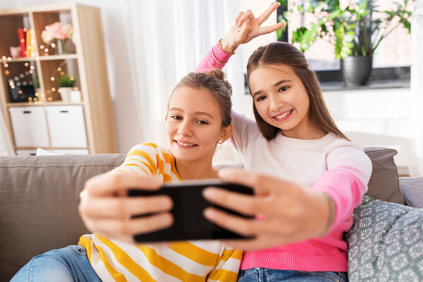 happy girls taking selfie with smartphone at home - Fotoğraf, Görsel