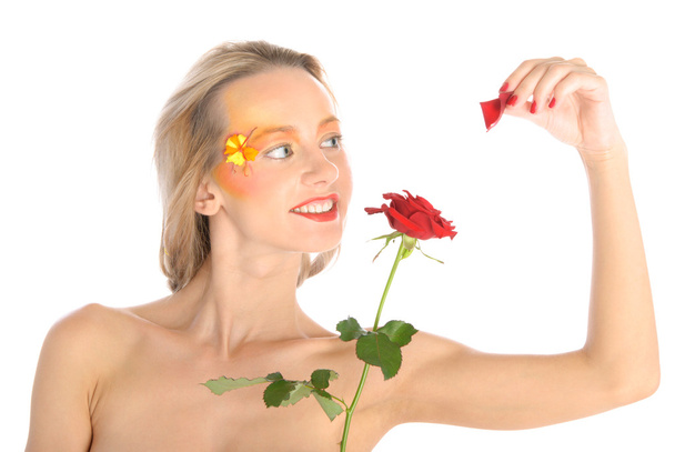 Young woman tears off petals at flower - Valokuva, kuva
