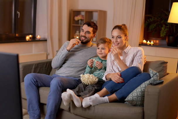 happy family with popcorn watching tv at home - Foto, Imagem