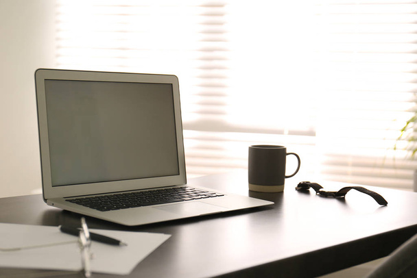 Ordenador portátil moderno en la mesa de oficina. Lugar de trabajo con estilo
 - Foto, imagen
