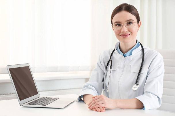 Portrait de jeune femme médecin en manteau blanc sur le lieu de travail
 - Photo, image