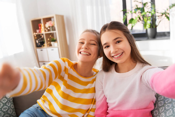 happy teenage girls taking selfie at home - Zdjęcie, obraz