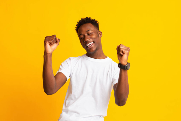 Portrait of young african guy having fun on yellow - Photo, Image