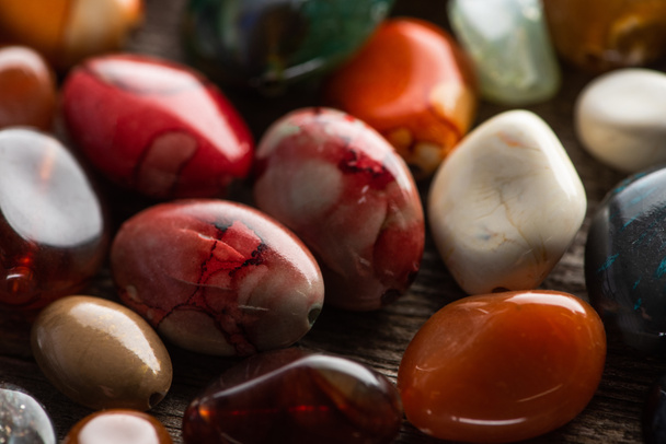 Close up view of shamanic colorful fortune telling stones on wooden background - Photo, Image