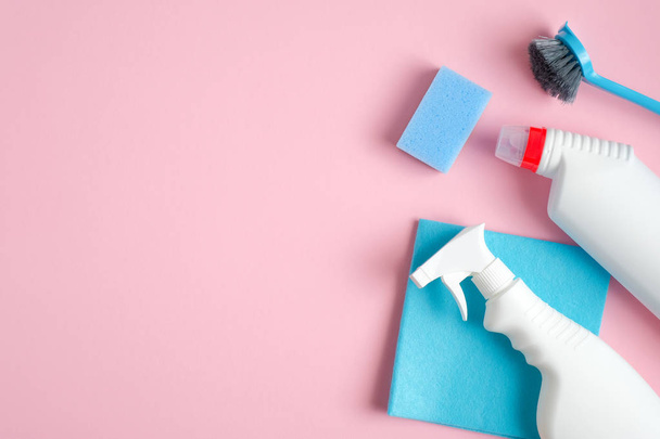 Cleaning supplies on pink background. Top view cleaner spray bottle, rag, sponge, detergent, brush. House cleaning service and housekeeping concept - 写真・画像