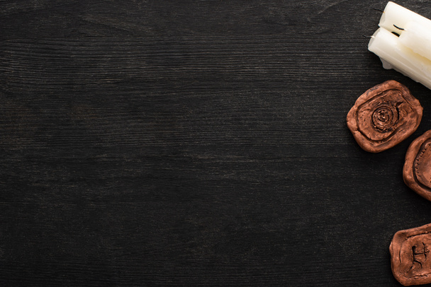 Top kilátás gyertyák és agyag amulettek sötét fából készült háttér másolási hely - Fotó, kép