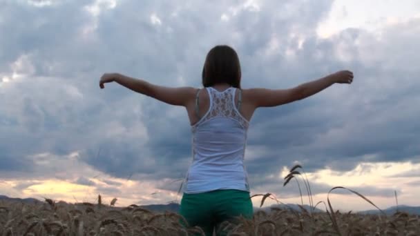 Женщина чувствует себя свободной на поле в жаркий летний день - Кадры, видео