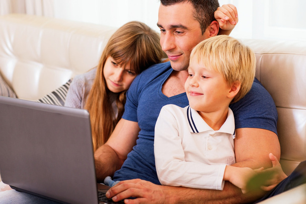 Padre con niños trabajando en el ordenador portátil
 - Foto, imagen